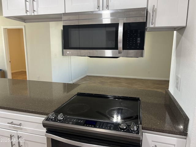 kitchen featuring white cabinetry, dark stone counters, and appliances with stainless steel finishes