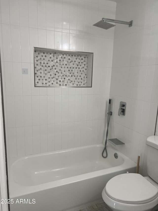 bathroom featuring tiled shower / bath and toilet