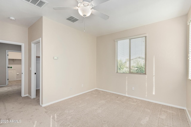 empty room featuring ceiling fan and light carpet