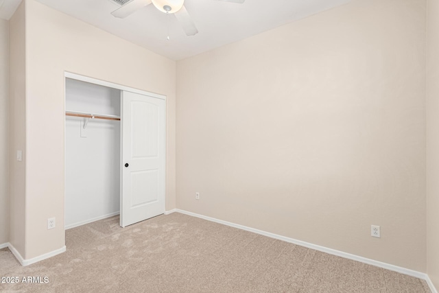 unfurnished bedroom with light colored carpet, ceiling fan, and a closet