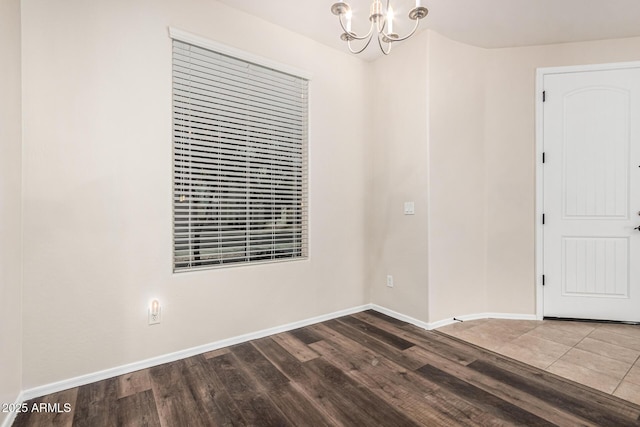 unfurnished room with dark hardwood / wood-style floors and a chandelier