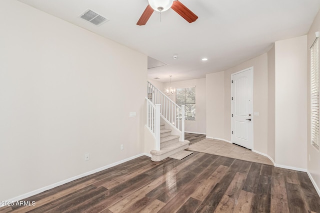 foyer with ceiling fan with notable chandelier and hardwood / wood-style floors