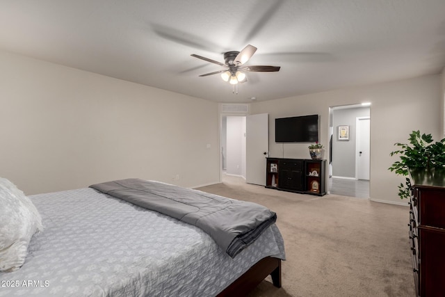 bedroom featuring light colored carpet, baseboards, and a ceiling fan