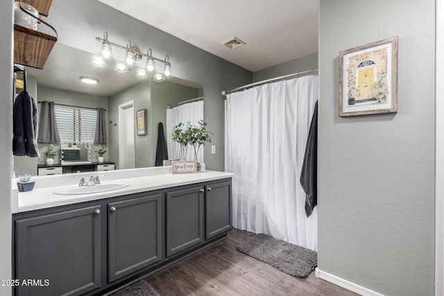 full bathroom featuring wood finished floors, vanity, and a shower with shower curtain