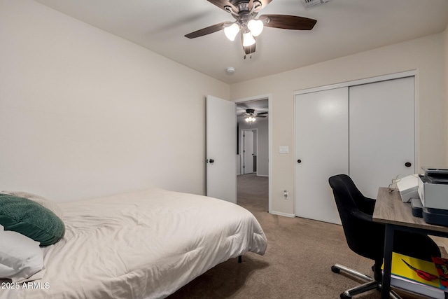 carpeted bedroom featuring a ceiling fan, an office area, and a closet