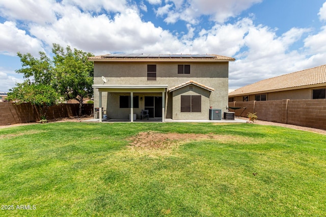 back of house with solar panels, a patio, stucco siding, and central AC