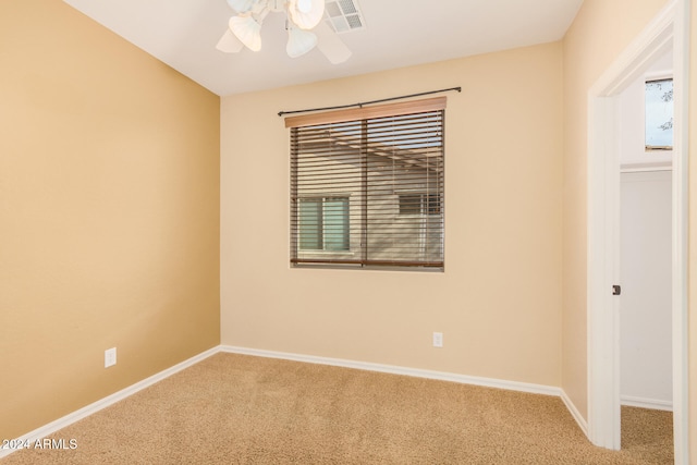 carpeted spare room featuring ceiling fan