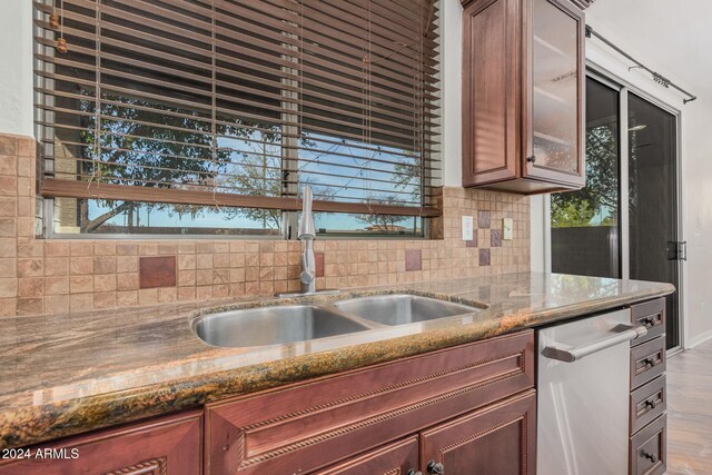 322 E Caribbean Dr, Casa Grande, AZ 85122 - kitchen with a sink, dishwasher, tasteful backsplash, glass insert cabinets, and dark stone counters