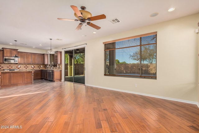 322 E Caribbean Dr, Casa Grande, AZ 85122 - unfurnished living room featuring ceiling fan, baseboards, light wood-type flooring, and recessed lighting