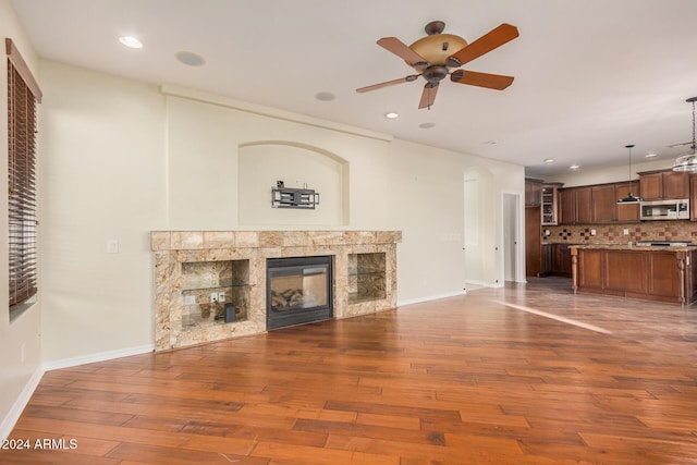 322 E Caribbean Dr, Casa Grande, AZ 85122 - unfurnished living room featuring ceiling fan, wood finished floors, recessed lighting, a tile fireplace, and baseboards