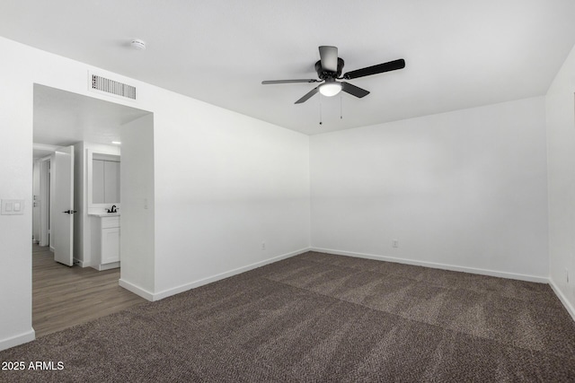 unfurnished room featuring dark carpet and ceiling fan