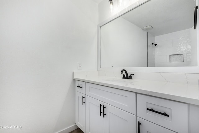 bathroom with vanity and a shower