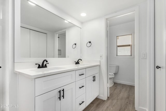 bathroom featuring vanity, toilet, and hardwood / wood-style floors