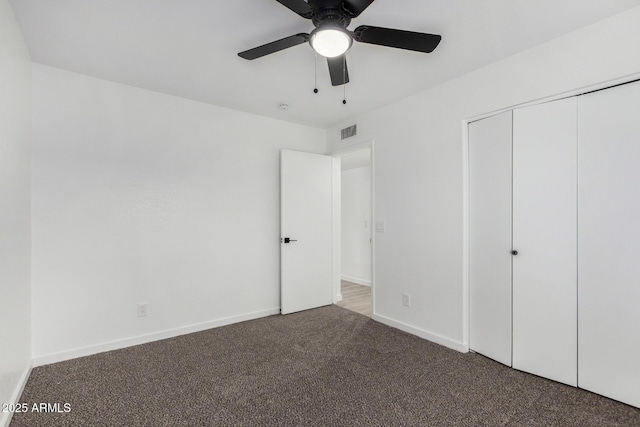 unfurnished bedroom with ceiling fan, carpet flooring, and a closet