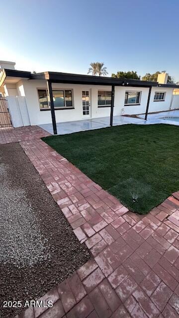 view of front of home with a patio area and a front yard