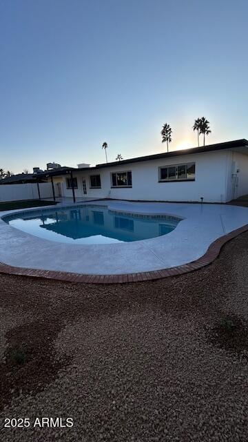 pool at dusk with a patio