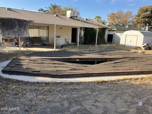 9033 N 15th Dr, Phoenix, AZ 85021 - back of house with a storage unit, an outbuilding, a deck, and roof with shingles
