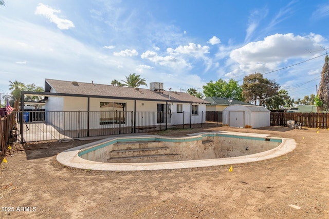 9033 N 15th Dr, Phoenix, AZ 85021 - rear view of house with a storage unit, a fenced backyard, an outdoor structure, and a patio area