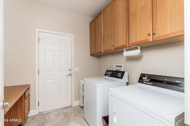 laundry area with cabinets and washing machine and clothes dryer