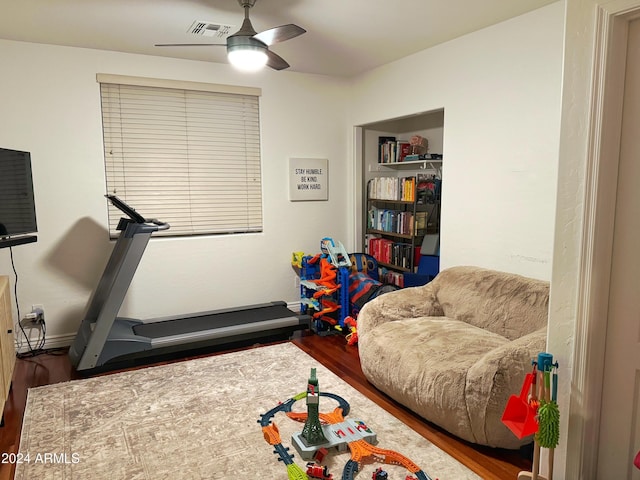 exercise area with ceiling fan and wood-type flooring