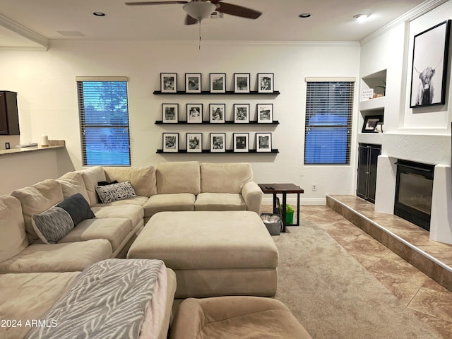 living room featuring built in shelves, ceiling fan, a tile fireplace, and ornamental molding