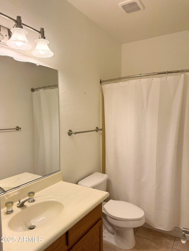 bathroom with tile patterned flooring, vanity, and toilet