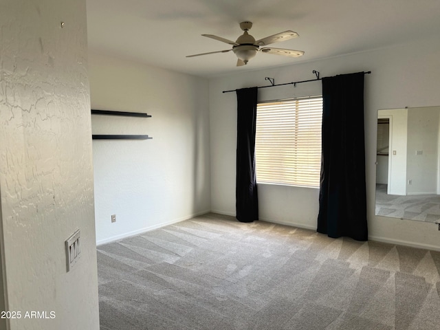 unfurnished room with light colored carpet and ceiling fan