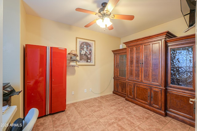 bedroom with high end refrigerator, baseboards, and a ceiling fan