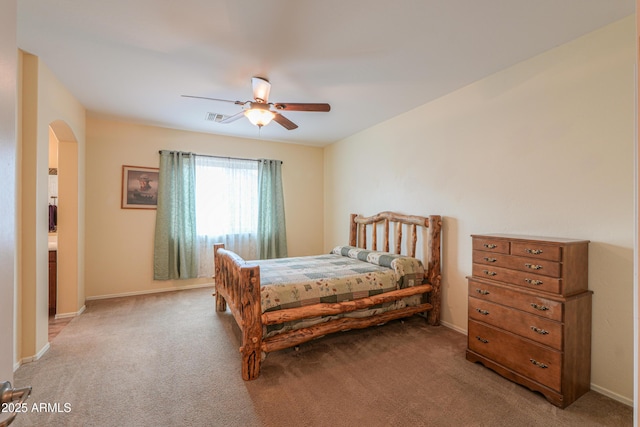 bedroom featuring arched walkways, light carpet, visible vents, and a ceiling fan