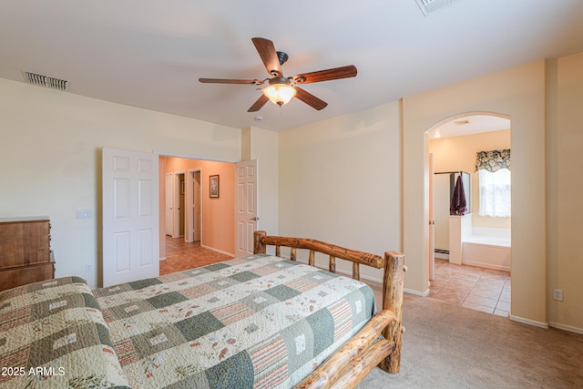 bedroom with carpet floors, arched walkways, visible vents, a baseboard heating unit, and ceiling fan