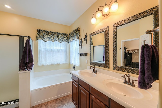 bathroom featuring double vanity, a sink, a bath, and tile patterned floors