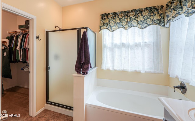 full bath featuring tile patterned flooring, vanity, a spacious closet, a shower stall, and a bath