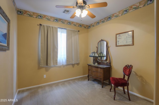 living area featuring carpet floors, visible vents, baseboards, and a ceiling fan