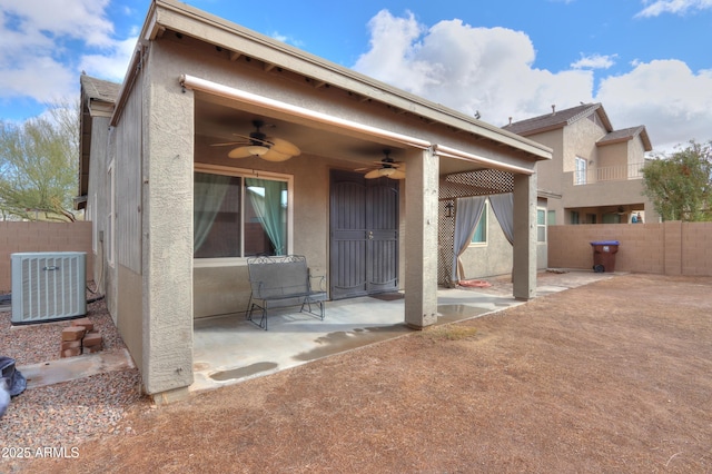 back of property featuring central AC, fence, and stucco siding