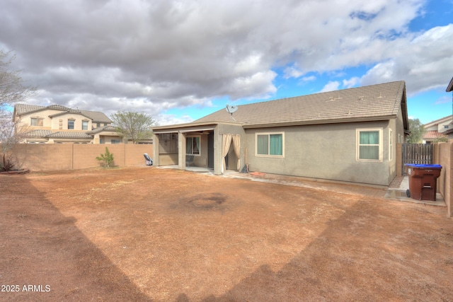 back of property featuring a fenced backyard and stucco siding