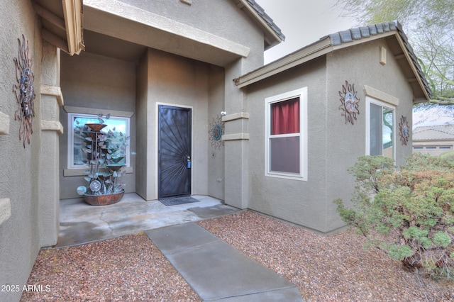 entrance to property featuring stucco siding