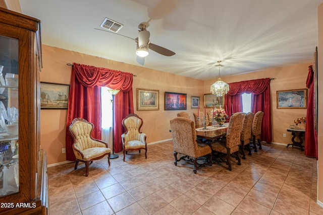 dining area with baseboards, ceiling fan with notable chandelier, visible vents, and light tile patterned flooring