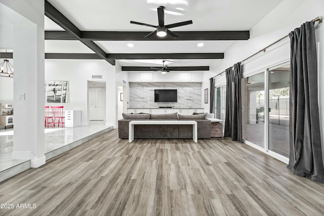 living room featuring beam ceiling, a notable chandelier, and light hardwood / wood-style flooring