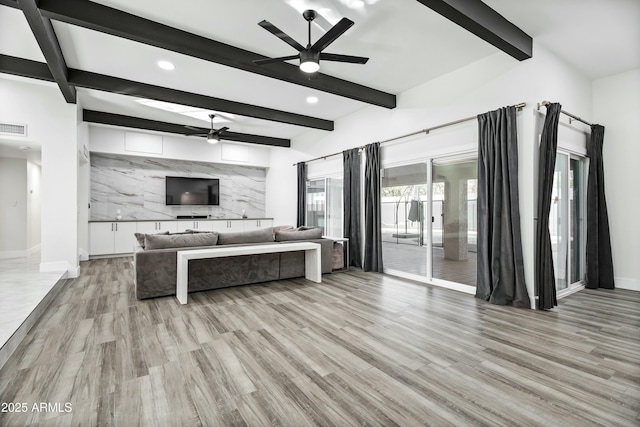 living room with ceiling fan, beamed ceiling, and light hardwood / wood-style flooring