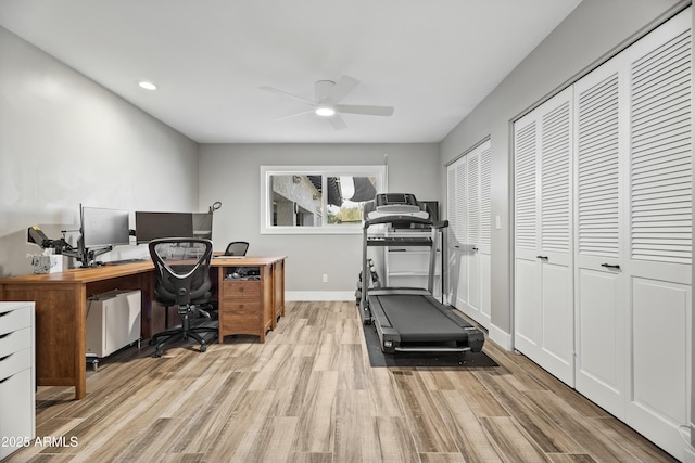 workout area with ceiling fan and light hardwood / wood-style floors