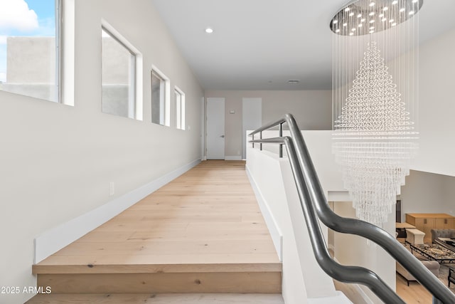 stairway featuring an inviting chandelier and hardwood / wood-style floors