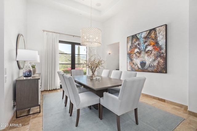 dining room featuring a towering ceiling and an inviting chandelier