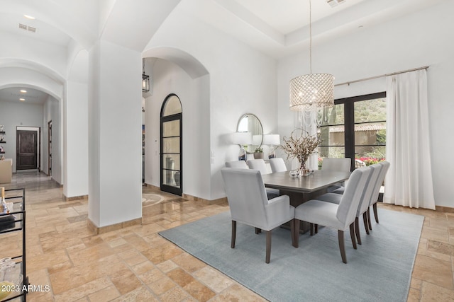 dining space featuring a towering ceiling