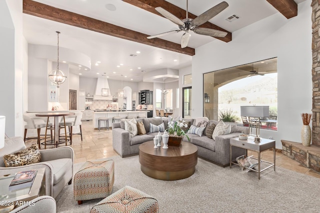 living room featuring beam ceiling and ceiling fan with notable chandelier