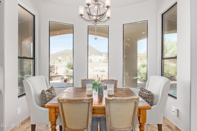 dining space featuring a mountain view, a wealth of natural light, and a chandelier