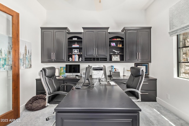 carpeted office space with built in desk