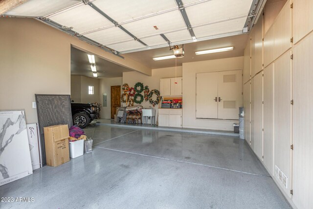 garage with electric panel and a garage door opener