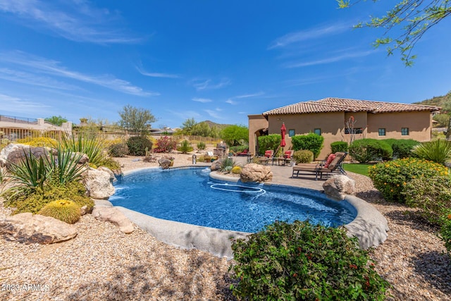 view of pool featuring pool water feature and a patio