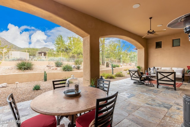 view of patio / terrace with ceiling fan, a mountain view, and an outdoor living space