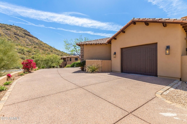 view of property exterior with a mountain view and a garage